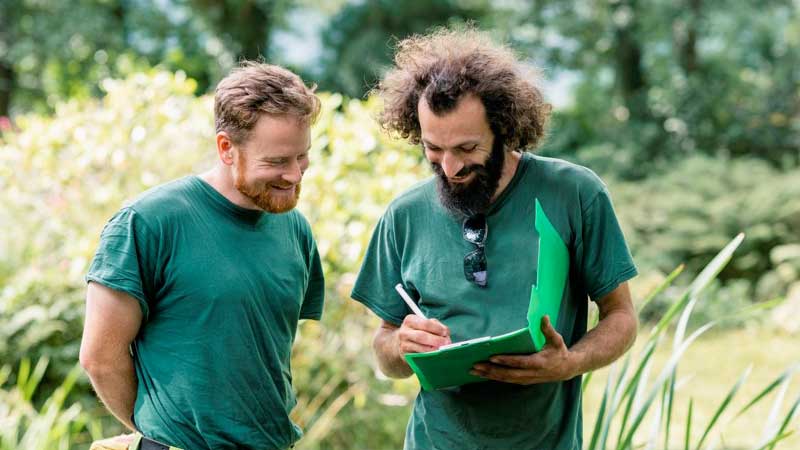 Two Men outside writing report