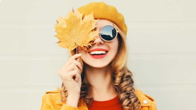 Lady wearng sunglasses holding a leaf